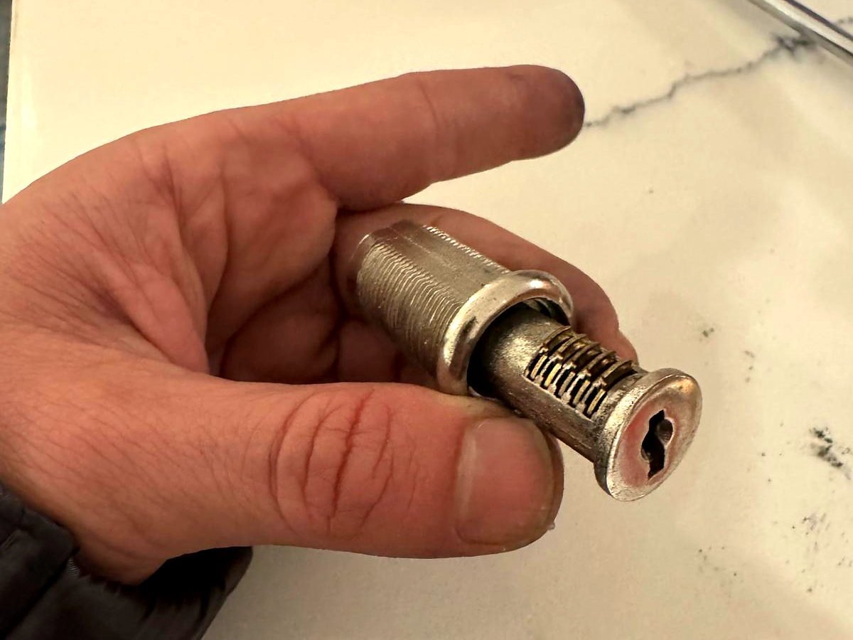 Lock cylinder removed from the door and held in the locksmith's hand ready to be rekeyed in San Diego