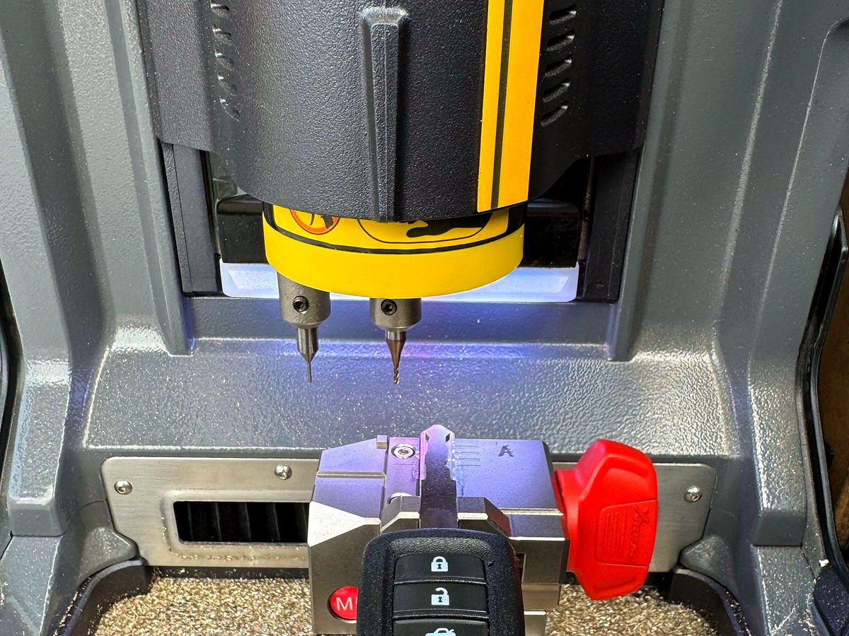 Car key blade being cut on the automatic key cutting machine in the G.D. Locksmith van in San Diego